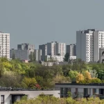 a city with tall buildings and trees in the foreground