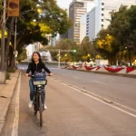 A woman rides a bicycle on a city street.