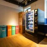 black and blue vending machine beside brown wooden cabinet
