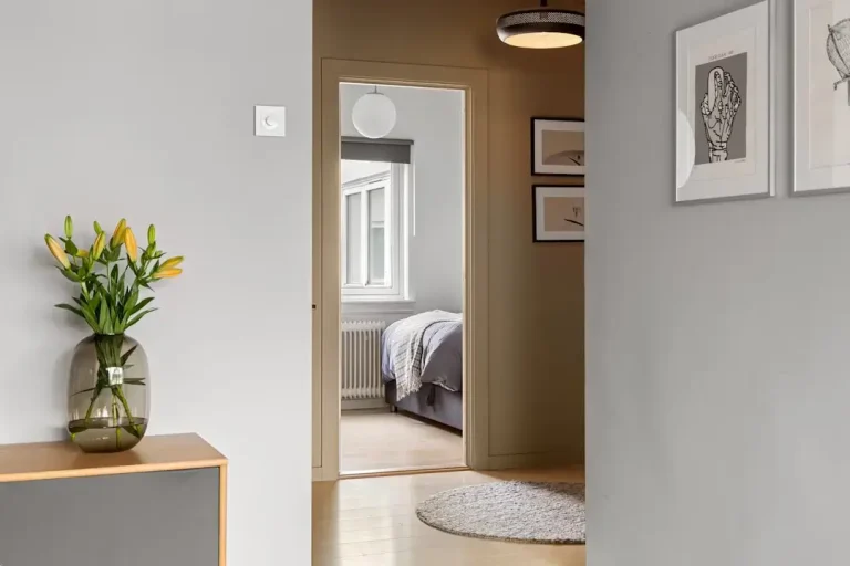 A modern smart thermostat mounted on a wall representing alternative energy-efficient home heating solutions
