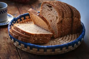 A fresh loaf of sliced bread on a wooden surface representing food waste management and recycling