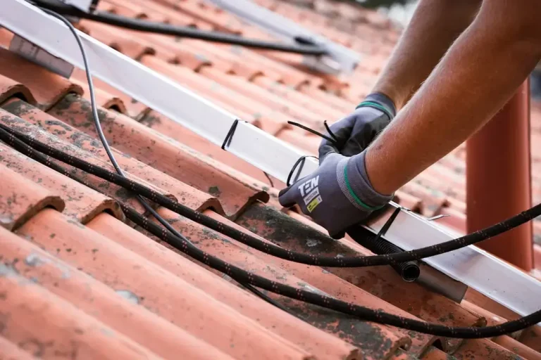 Professional technicians installing modern solar panels on a residential rooftop for clean renewable energy.
