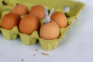 Handmade Easter decorations created from recycled materials like cardboard and egg cartons on a wooden table.