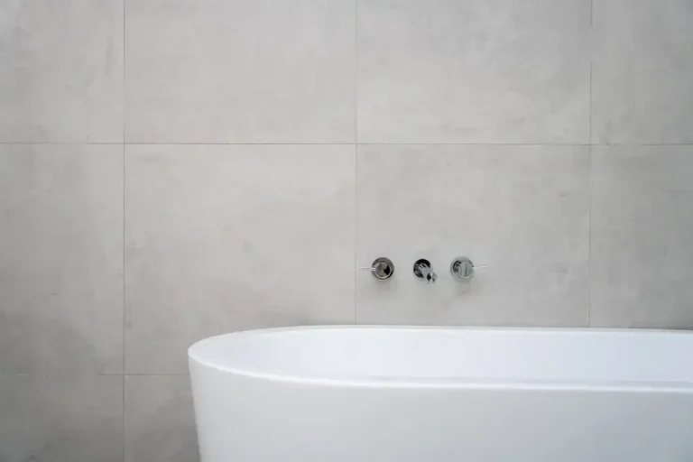 A modern chrome bathroom faucet mounted on a clean ceramic sink, representing plumbing hardware disposal.