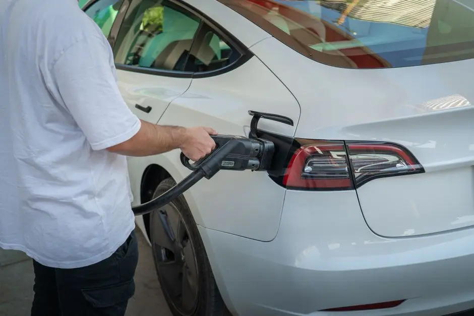 Samochód elektryczny ładowany na stacji, symbol ekologicznego transportu.
