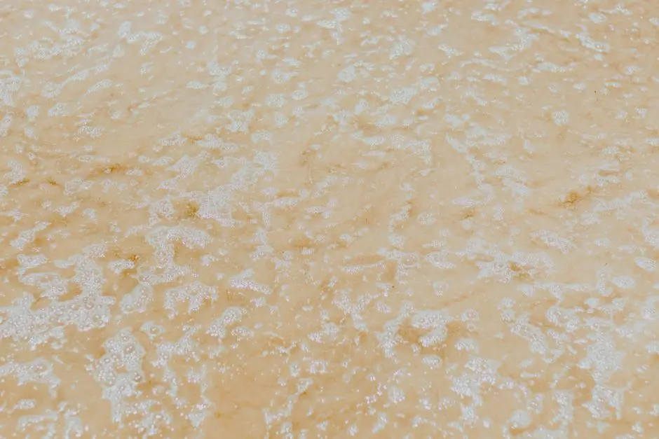 Zbliżenie na piaszczyste fale oceaniczne tworzące teksturowane tło plaży.
