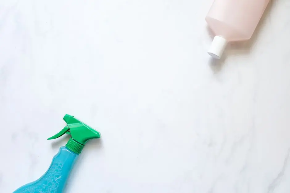 Widok z góry sprayu czyszczącego i butelki na białej powierzchni z dużą ilością miejsca na tekst.